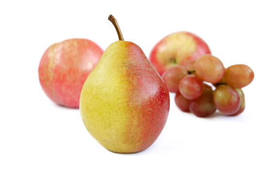 pear fruits, yellow fruits with red edges on the background of apples and grapes, grapes