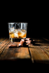 malt scotch whiskey with ice and chocolate on wooden table