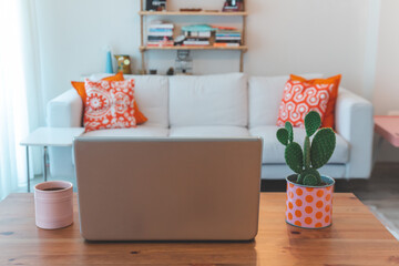 Leptop mug and cactus on home decor table.
