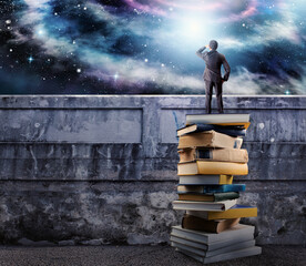 Businessman over a pile of books observe the universe full of sky. the culture open the imagination © alphaspirit