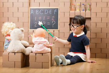 toddler girl pretend play as a teacher at home