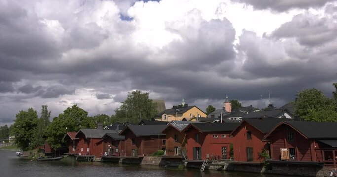 4K video of Porvoo vintage red wooden buildings, Porvoo Cathedral, yachts and boats in Porvoonjoki River near town center on sunny summer day in Finland, northern Europe