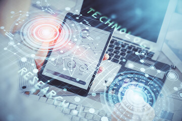 Double exposure of man's hand holding and using a digital device and data theme hologram drawing. Technology concept.