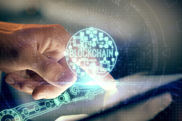 Double exposure of man's hands holding and using a phone and crypto currency blockchain theme...