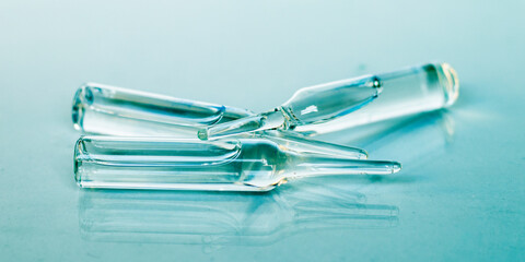 Medical ampoules close-up. Three glass ampoules on a blue background. Selective focus. Medical concept.