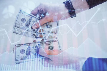 Multi exposure of financial graph drawing hologram and USA dollars bills and man hands. Analysis concept.