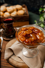 Plum confiture in a glass jar on a white towel
