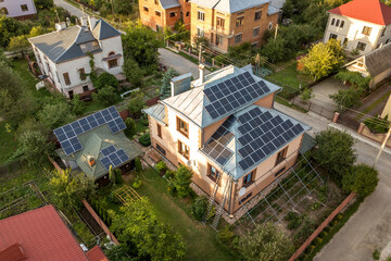Obraz premium Aerial top view of new modern residential house cottage with blue shiny solar photo voltaic panels system on roof. Renewable ecological green energy production concept.