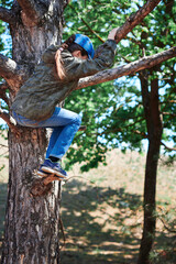 Girl playing outdoor, climbing a tree, bright sunlight, beautiful day