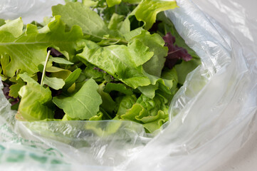 close up of mixed greens in a clear plastic bag