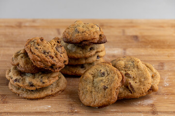 stacks of chocolate chip cookies on a bamboo board