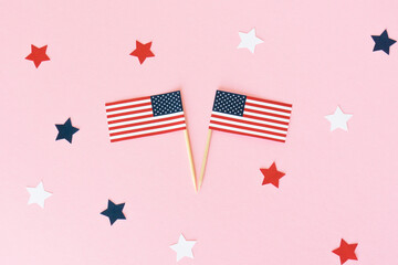Two american flag toothpick and star on pink background, flat lay. 4th of july, usa independence day. Celebration in America.