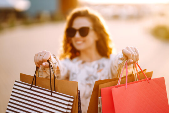 Woman in shopping. Young Girl with colorful shopping bags  walking around the city after shopping. Consumerism, purchases, shopping, lifestyle concept.