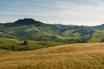 Oltrepo' Pavese landscape hills with wineyards and country roads and Montalto Pavese castle in the background in a sunny day