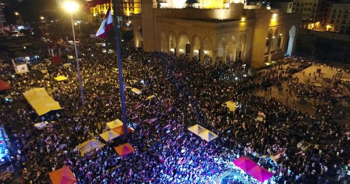 Beirut Lebanon 2019 : night drone shot track back in Martyr square with thousands of protesters revolting against government corruption and failure during the Lebanese revolution