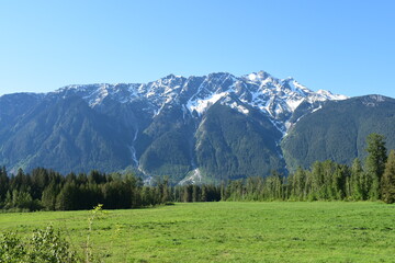 snow mountains blue sky green fields canada