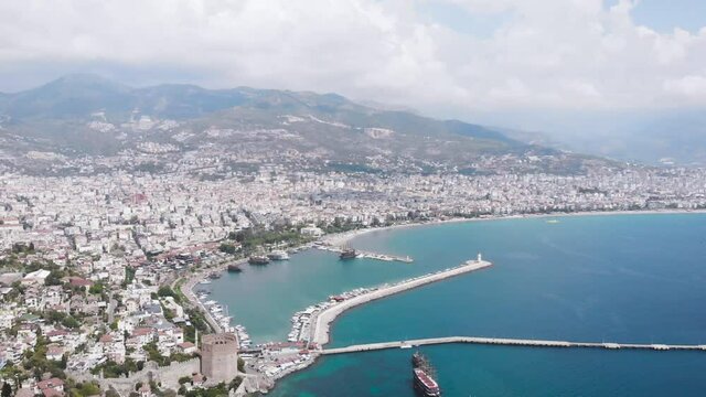 Aerial view landscape of Alanya through the arch of the old fortress. View of the city beach and coastline. Hotels in Alanya.