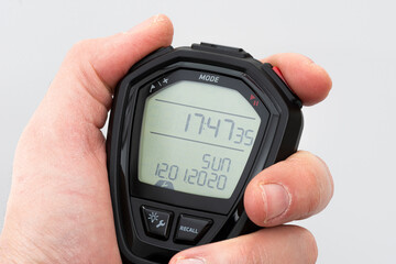 Man holding digital stopwatch on the white background.
