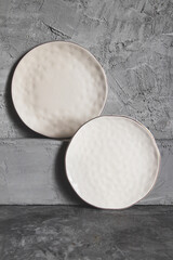 Gray empty plates (ceramic) on a gray stone background. Gray minimalism concept