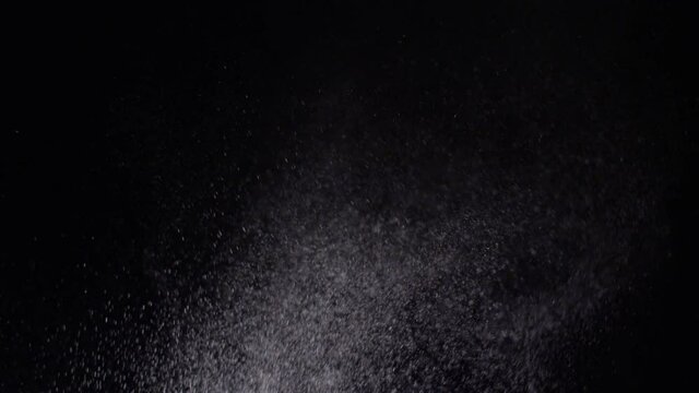 Water spraying droplets snow storm on a black background texture effect