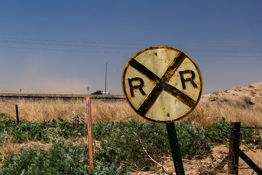 Battered old railroad crossing sign on a country road on the prairie