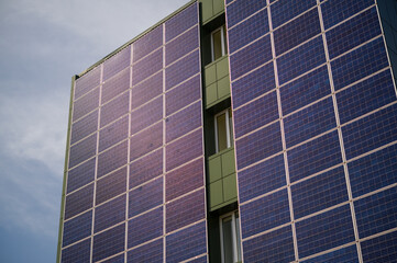 Obraz premium solar panels on the wall of an industrial building for electricity during the day in the city