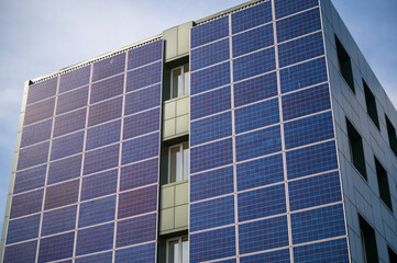 solar panels for generating electricity on the wall of an industrial building in the city during...