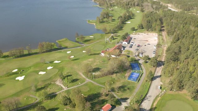 Aerial view of golf course & clubhouse along the shore