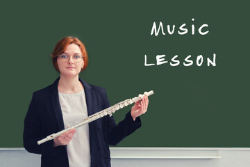 Woman music teacher on the background of a blackboard, copy space