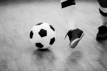 Black and white image of Futsal ball with motion blurry futsal player run and contol ball to shoot ...