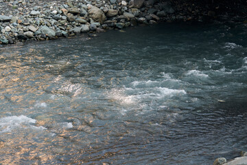 nature and travel concept - river water flow and stones