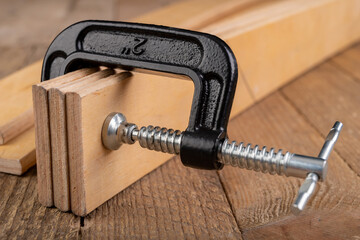 Carpentry clamp used for gluing wood. Carpentry accessories in a home workshop.