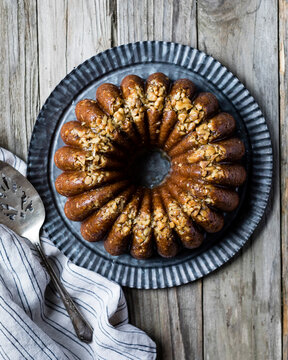 Maple walnut bundt cake on a fluted tin plate.
