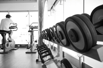 Staying fit and healthy with cardio fitness equipment, treadmills and free weights in gym or...