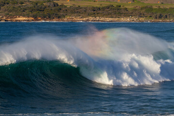 a rainbow in a wave at the beach