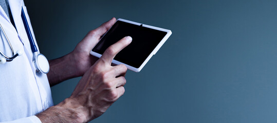Male doctor using his digital tablet