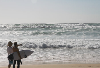 surfers on the beach. looking for a place to go for a surf