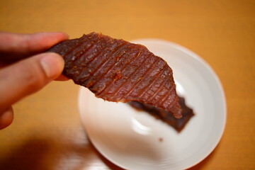 ビーフジャーキーを手に持つ