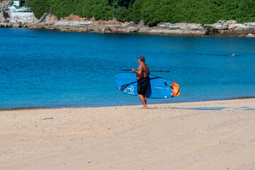 Active male man in ref kayak at the beach/ catching waves in canoe