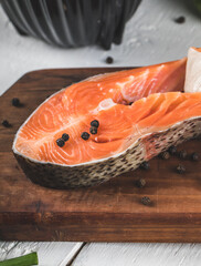 Salmon slices with black pepper balls on a wooden board