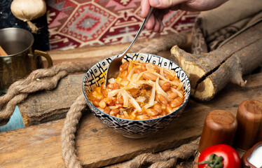 Traditional caucasian beans with rice and pasta taking food with a spoon