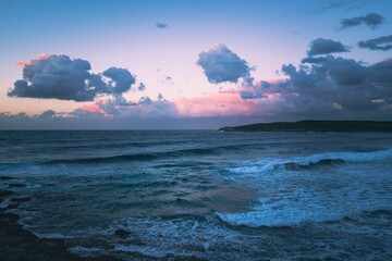 sunset on the beach, pink and blue clouds setting over the beach in winter