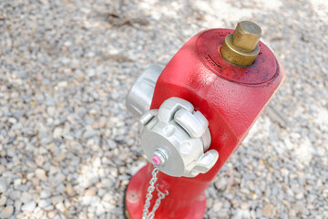 Naklejka premium Red metal fire hydrant on the street in an industrial area for fire safety.