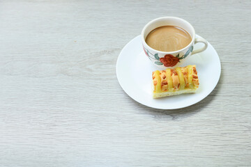 Cut of cheese bread and cup of coffee on wooden table 