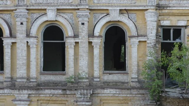 Broken arched windows in abandoned old manor (mansion) house. Deserted 19th century building. Aerial side view.