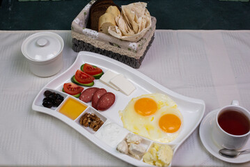 Breakfast platter with fried eggs and a cup of tea
