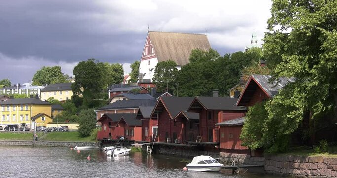4K video of Porvoo vintage red wooden buildings, Porvoo Cathedral, yachts and boats in Porvoonjoki River near town center on sunny summer day in Finland, northern Europe