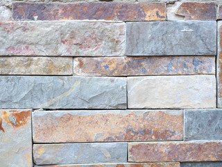 masonry of colored bricks made of natural stone, wall surface texture, bright colors background