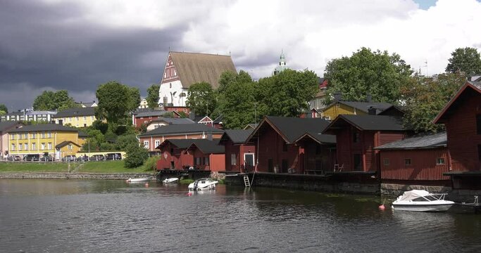 4K video of Porvoo medieval vintage cathedral, Porvoo Cathedral, yachts and boats in Porvoonjoki River near town center on sunny summer day in Finland, northern Europe