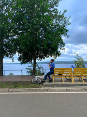 Photo of a girl with a bicycle, who is resting after doing sports on a bench